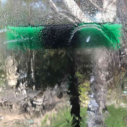 Water fed pole brush head nozzle spraying water to clean window.